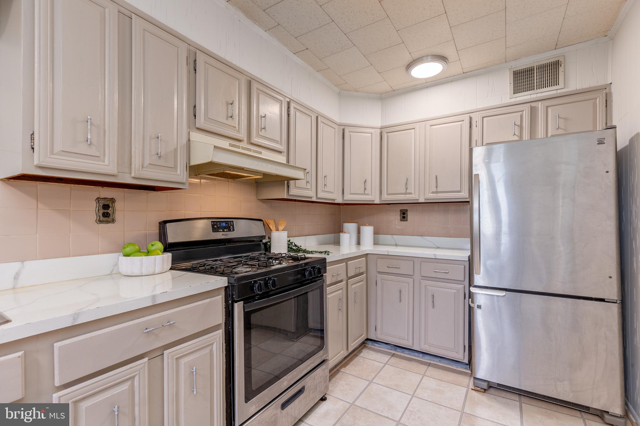 6426 Sherwood Road Baltimore, MD 21239 - Photo 14 of 43 a kitchen with cabinets and stainless steel appliances