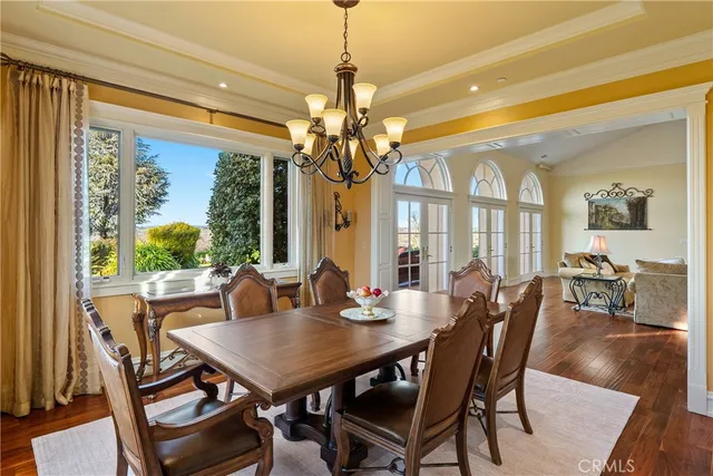 a bedroom with a bed a large window with table and chairs