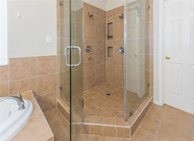 a bathroom with a bathtub and shower