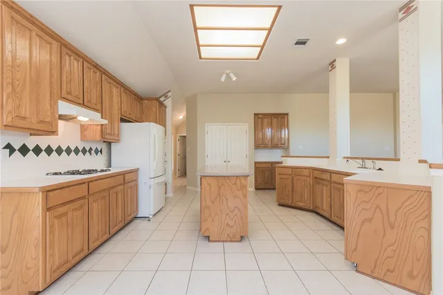 a large kitchen with a lot of counter space and wooden floor