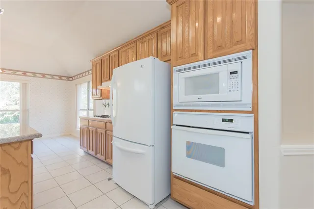 a white refrigerator freezer and a stove sitting inside of a kitchen