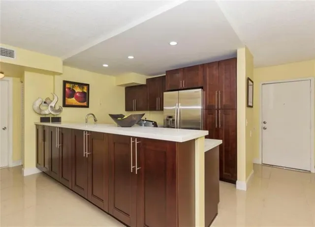 a view of kitchen with stainless steel appliances granite countertop a refrigerator and a sink