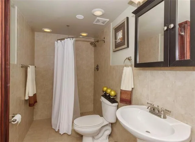 a bathroom with a sink toilet and shower