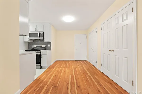 a open kitchen with white cabinets and stainless steel appliances