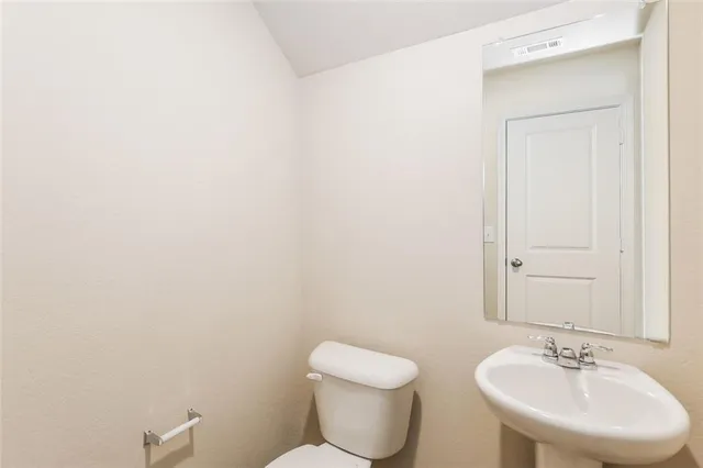 a bathroom with a toilet a sink and mirror