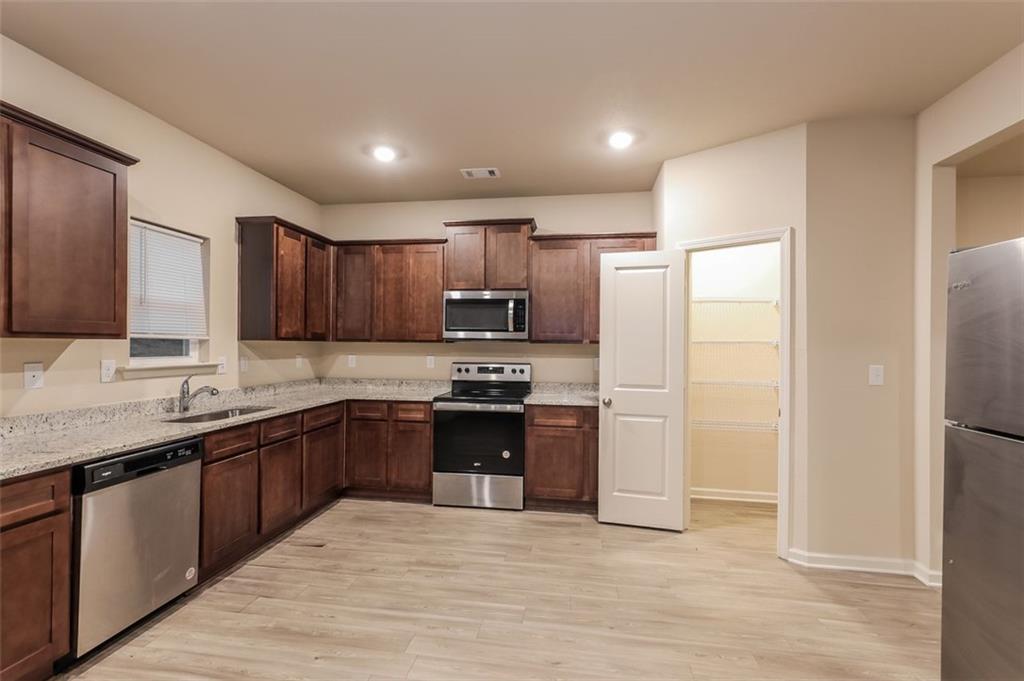 148 Oliver Drive Locust Grove, GA 30248 - Photo 3 of 17 a modern kitchen with stainless steel appliances granite countertop a refrigerator and a sink