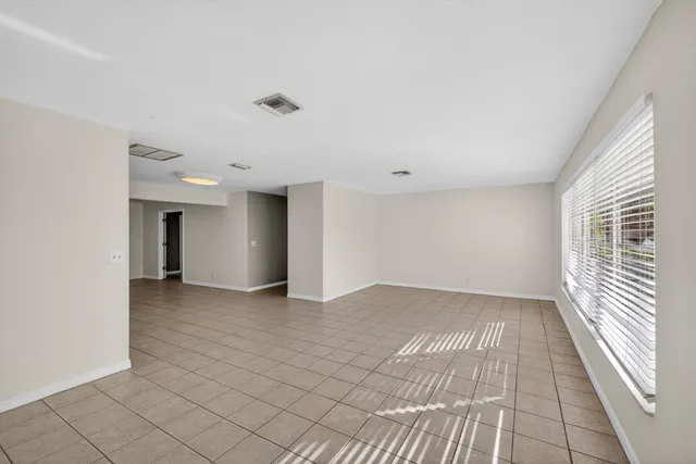 a view of a big room with wooden floor and windows