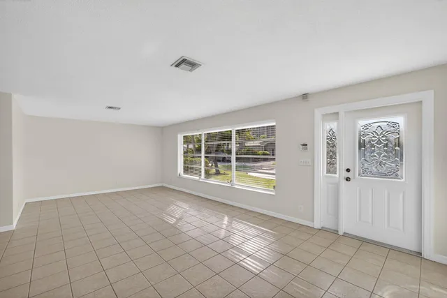 a view of empty room with wooden floor and window
