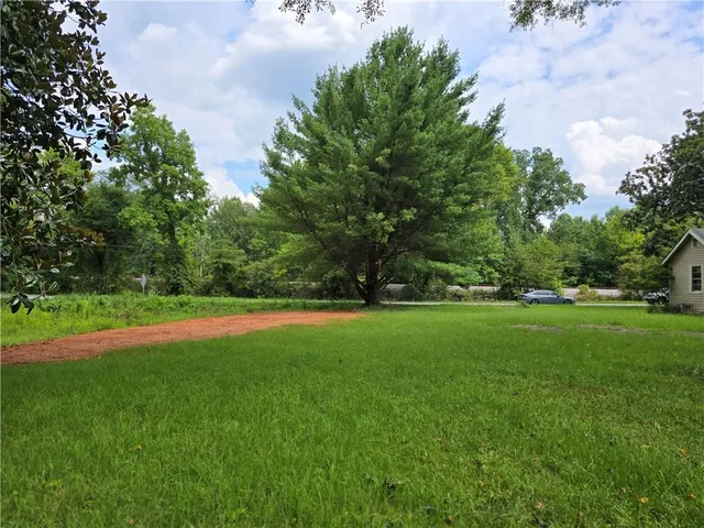 a view of a field of grass and trees