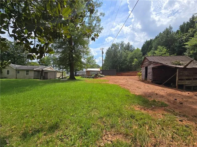 a view of a house with backyard and a tree