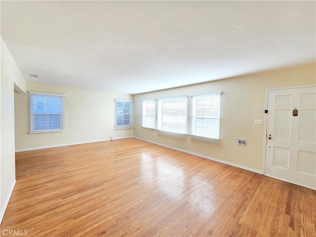 3869 Bandini Avenue Riverside, CA 92506 - Photo 3 of 17 a view of an empty room with wooden floor and a window