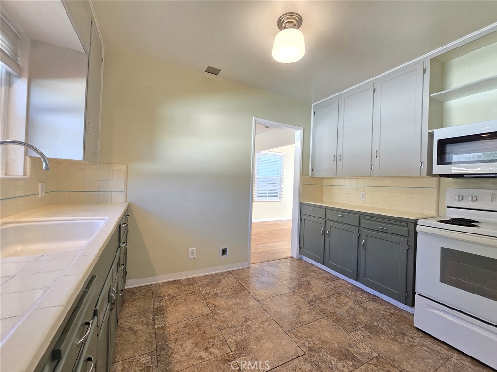 3869 Bandini Avenue Riverside, CA 92506 - Photo 7 of 17 a kitchen with stainless steel appliances granite countertop a sink and a stove