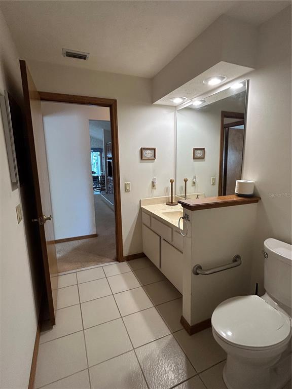 9528 Southeast 70th Terrace Ocala, FL 34472 - Photo 17 of 43 a bathroom with a sink a toilet a mirror and vanity