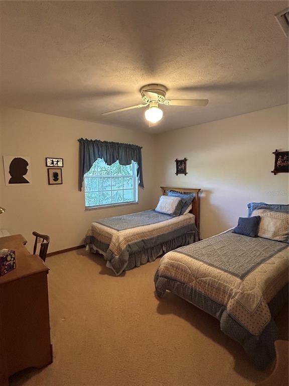 9528 Southeast 70th Terrace Ocala, FL 34472 - Photo 19 of 43 a bedroom with two beds and a chandelier