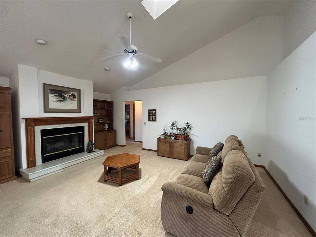 9528 Southeast 70th Terrace Ocala, FL 34472 - Photo 3 of 43 a living room with furniture ceiling fan and a fireplace