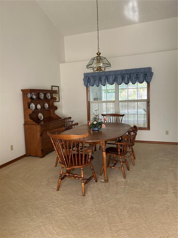 9528 Southeast 70th Terrace Ocala, FL 34472 - Photo 10 of 43 a dining room with furniture a chandelier and window
