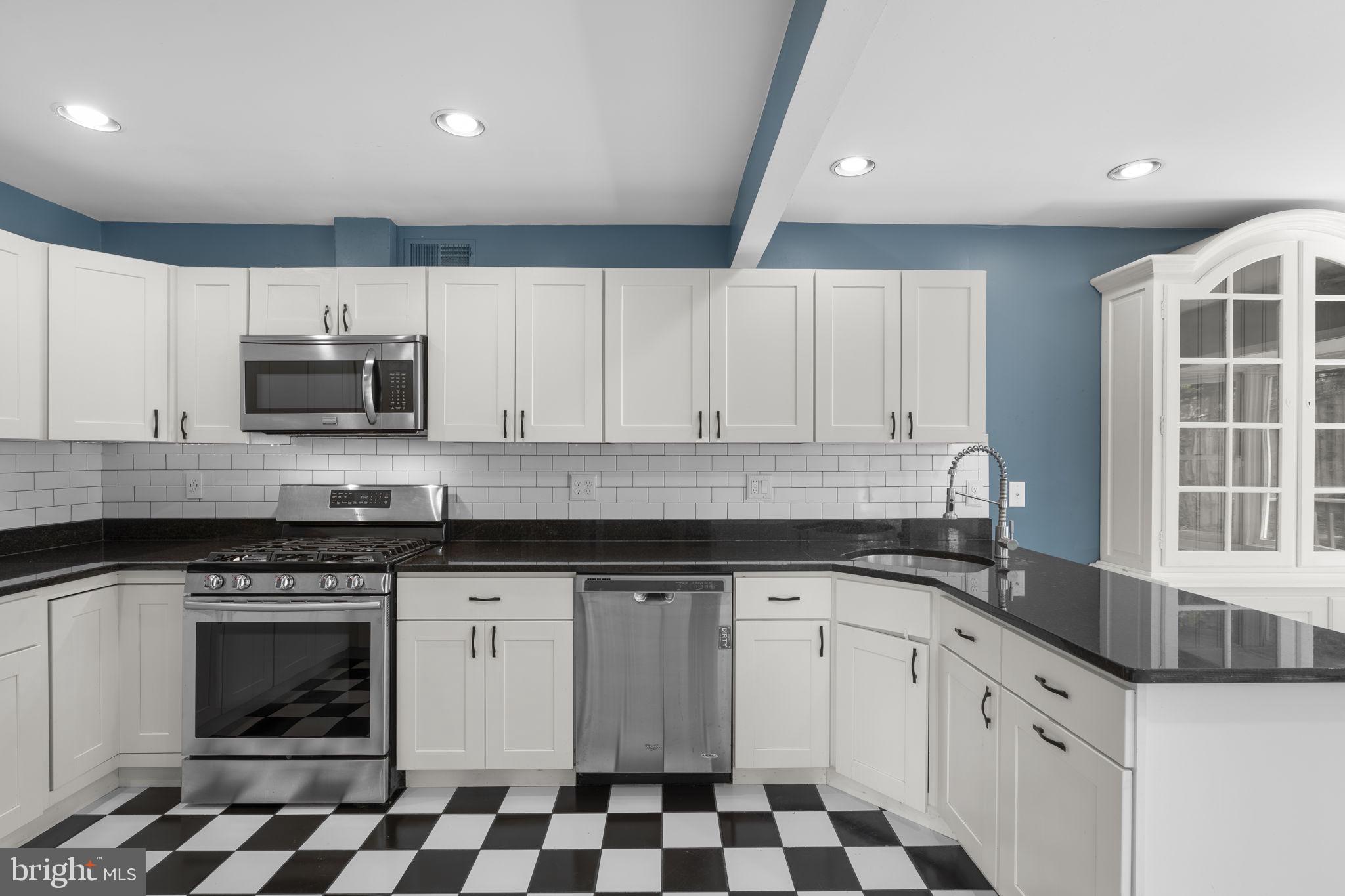 822 Loxford Terrace Silver Spring, MD 20901 - Photo 19 of 61 a kitchen with granite countertop white cabinets and black appliances