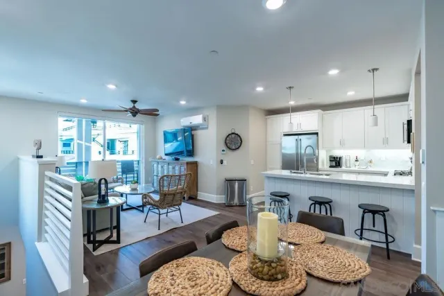 a living room with furniture kitchen view and a wooden floor