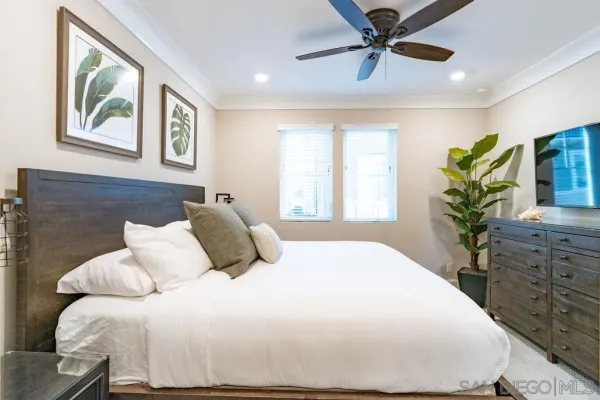 a bedroom with a large bed and a chandelier