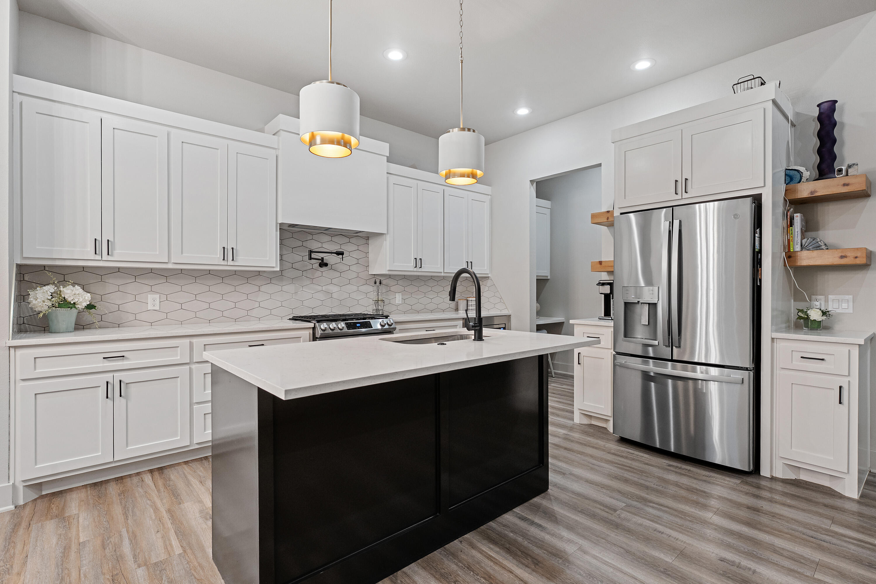 7814 55th Street Lubbock, TX 79407 - Photo 5 of 27 a kitchen with refrigerator cabinets and wooden floor