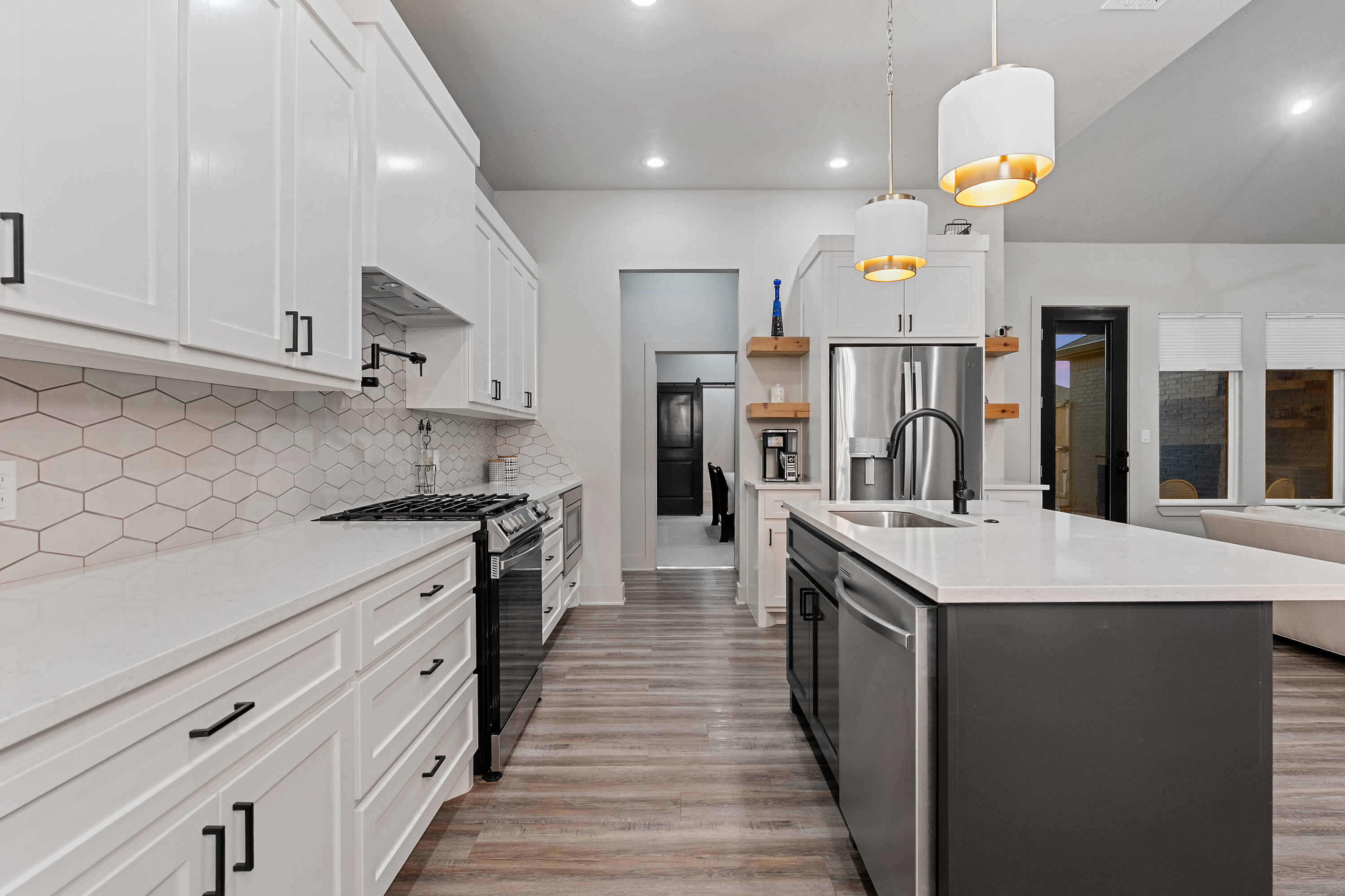 7814 55th Street Lubbock, TX 79407 - Photo 6 of 27 a kitchen with a sink a refrigerator and a stove top oven