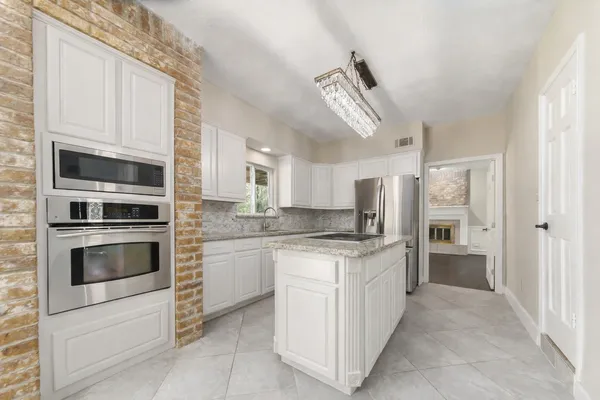 a kitchen with stainless steel appliances granite countertop a stove and cabinets