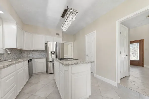 a kitchen with stainless steel appliances granite countertop a sink and a refrigerator