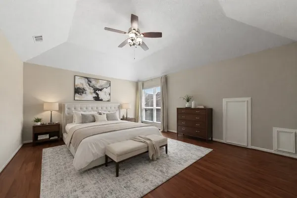 a bedroom with a bed and wooden floor