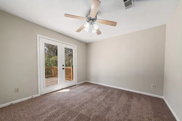 an empty room with fan and windows
