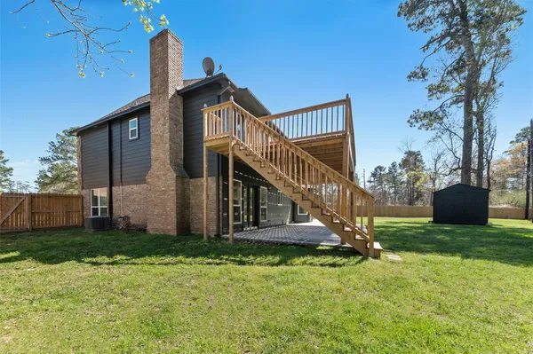 a view of a house with backyard and fence