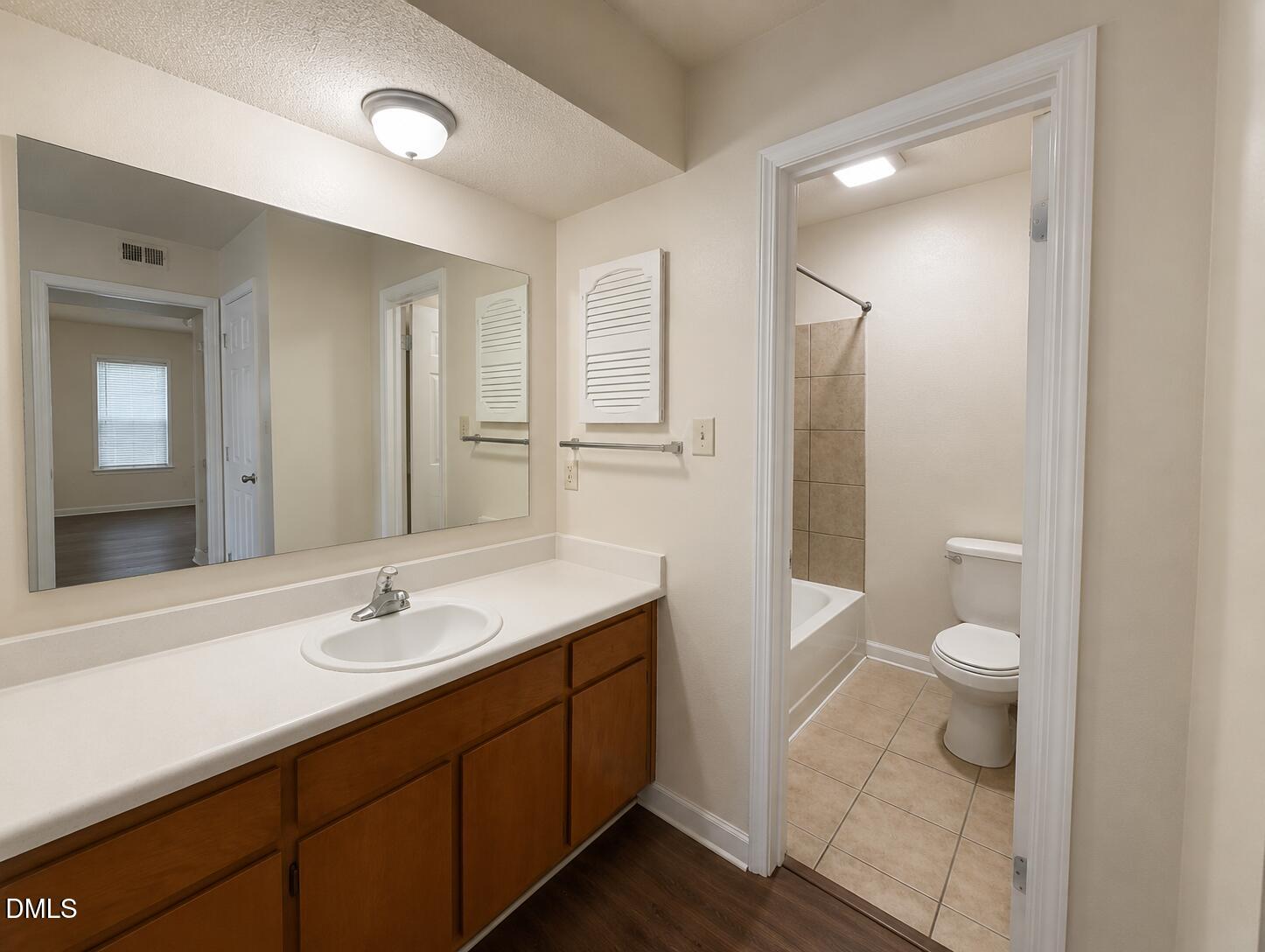 2506 Avent Ferry Road, Unit 101 Raleigh, NC 27606 - Photo 14 of 19 a bathroom with a sink a toilet and a large mirror