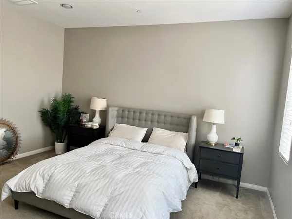 a bedroom with a bed and a potted plant