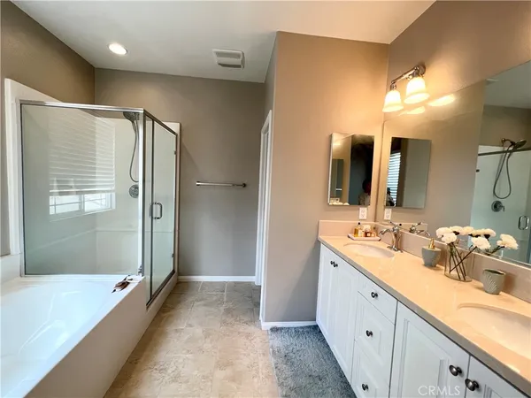 a spacious bathroom with a double vanity sink mirror and shower