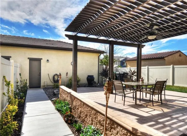 a view of a patio with table and chairs potted plants with floor to ceiling window