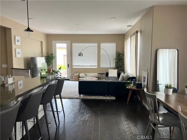 a living room with furniture potted plant a sink and a large window
