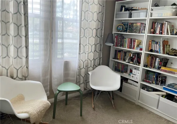a view of a livingroom with furniture and a book shelf