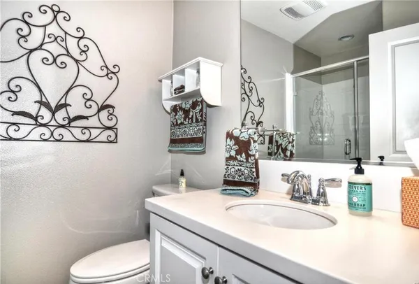 a bathroom with a sink vanity mirror and toilet