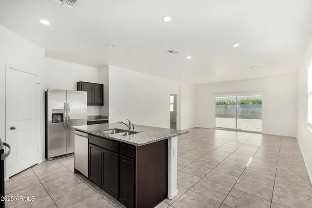 a kitchen with stainless steel appliances granite countertop a stove a refrigerator and a sink