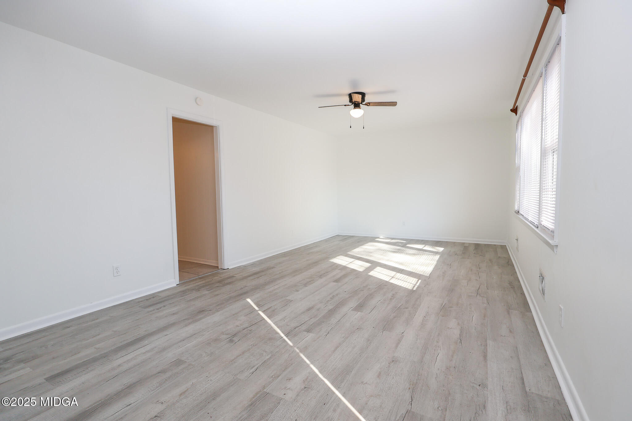 105 Larryton Drive Cochran, GA 31014 - Photo 5 of 34 an empty room with wooden floor and windows