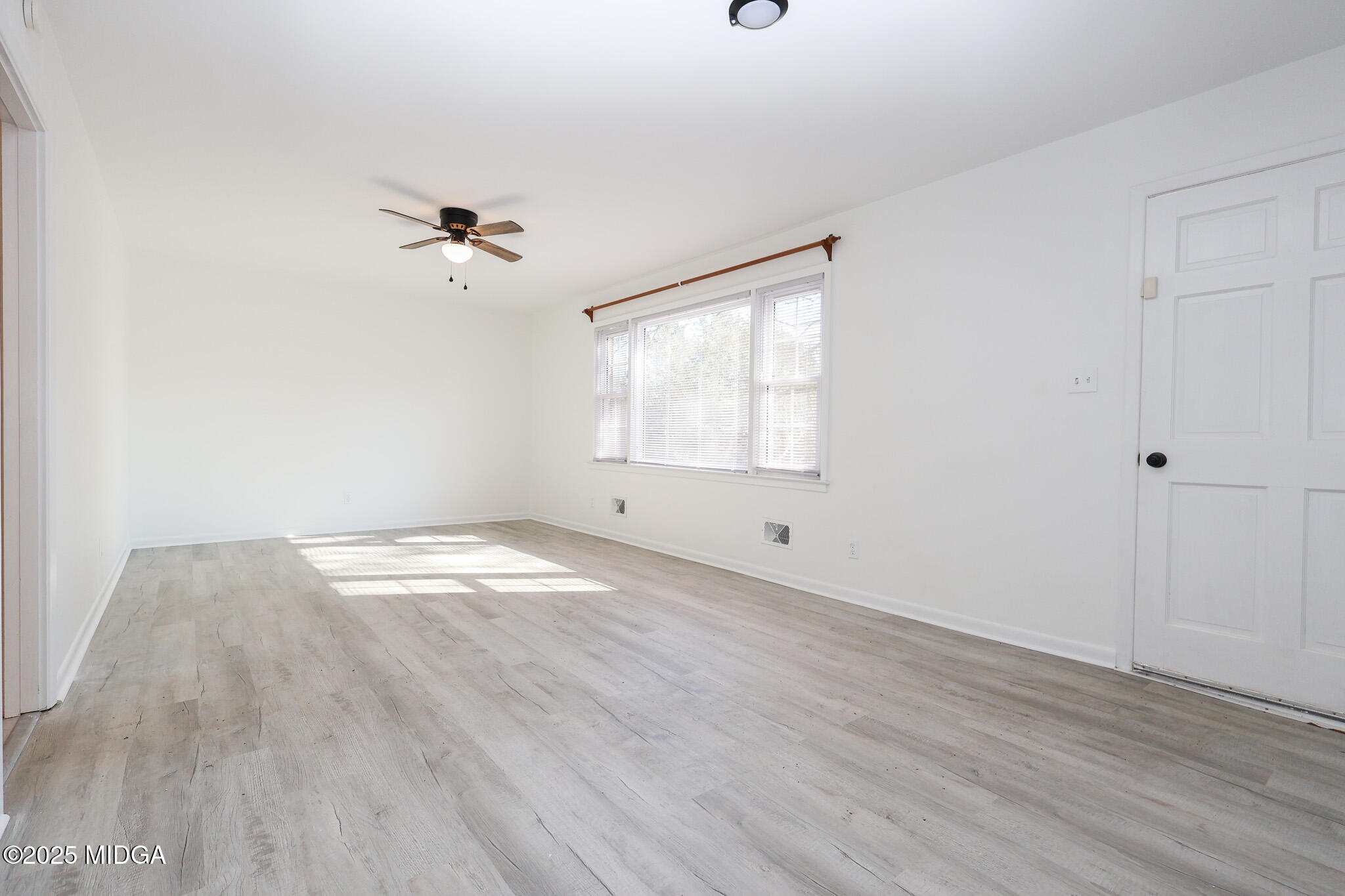 105 Larryton Drive Cochran, GA 31014 - Photo 6 of 34 a view of empty room with wooden floor and fan