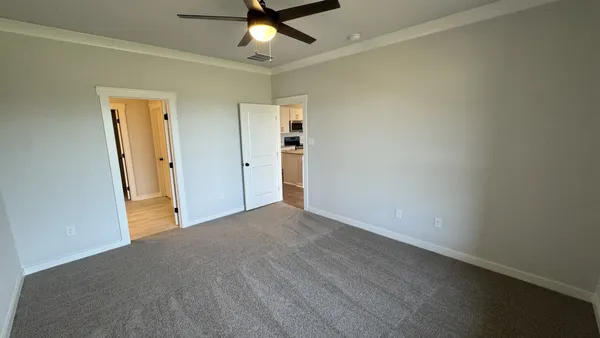 an empty room with closet and a chandelier fan