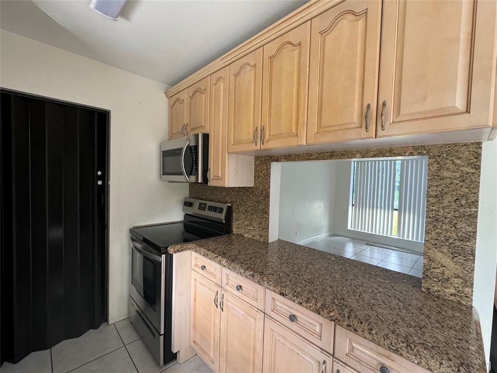6101 Northwest 18th Street Margate, FL 33063 - Photo 11 of 22 a kitchen with granite countertop stainless steel appliances a stove top oven and cabinets