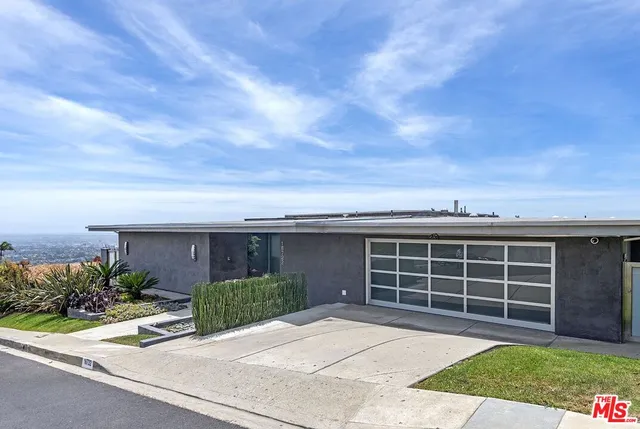 front view of a house with a yard and potted plants