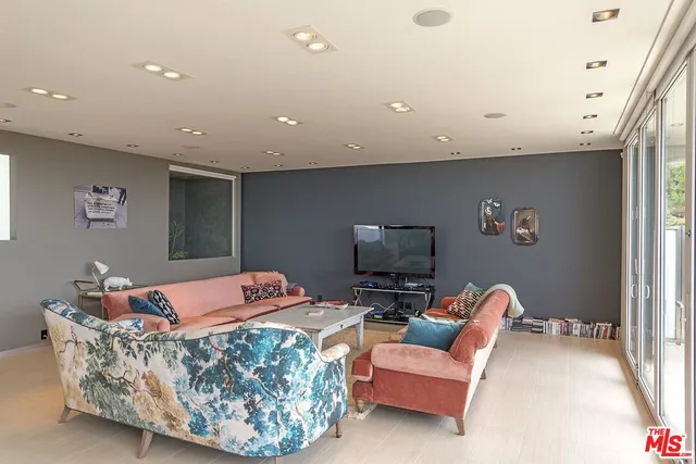 a living room with furniture and view of kitchen