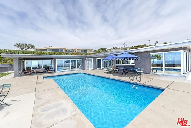 a view of house with swimming pool outdoor seating