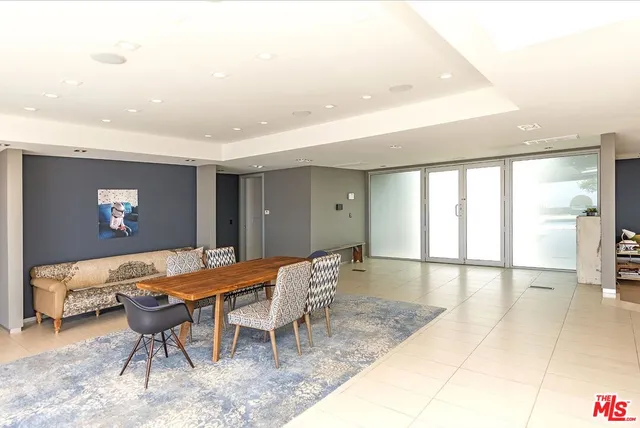 a large white kitchen with a large window and couch