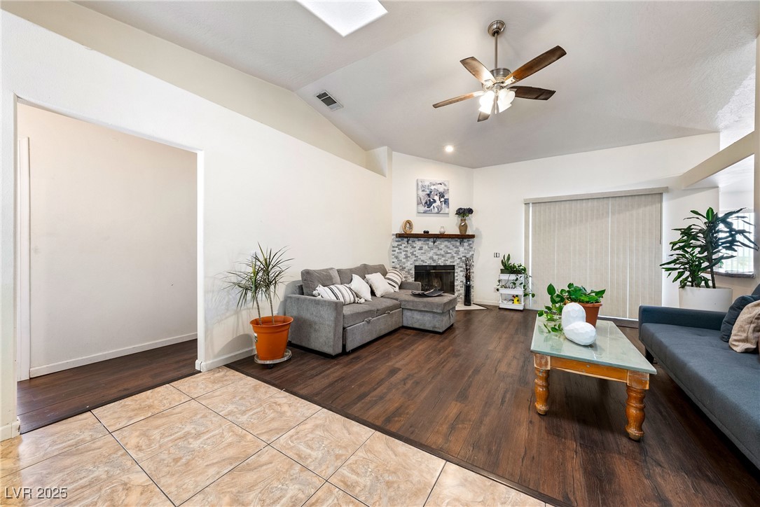 3481 Winery Road Pahrump, NV 89048 - Photo 22 of 34 Living area featuring ceiling fan, a fireplace, lofted ceiling, wood finished floors, and baseboards