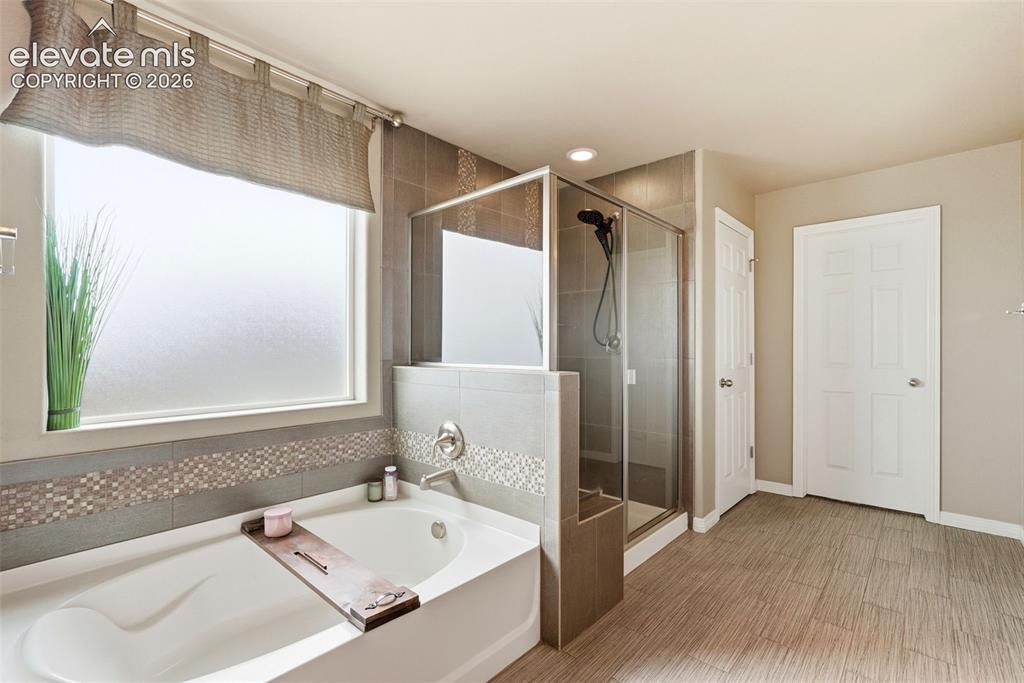 2264 Reed Grass Way Colorado Springs, CO 80915 - Photo 33 of 50 a bathroom with a tub sink and mirror