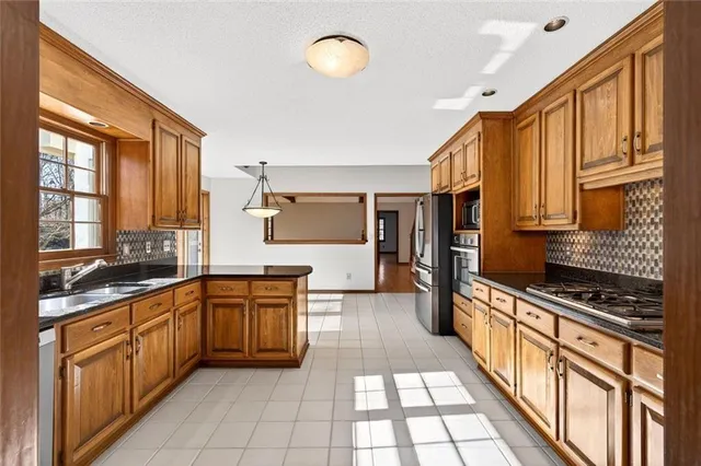 an empty room with wooden floor chandelier and windows