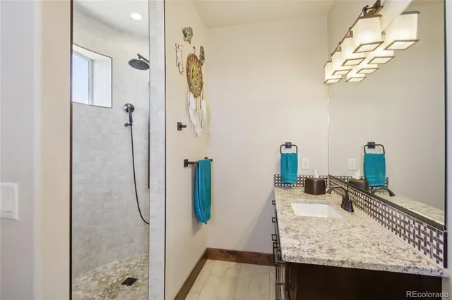 a bathroom with a granite countertop sink and a mirror